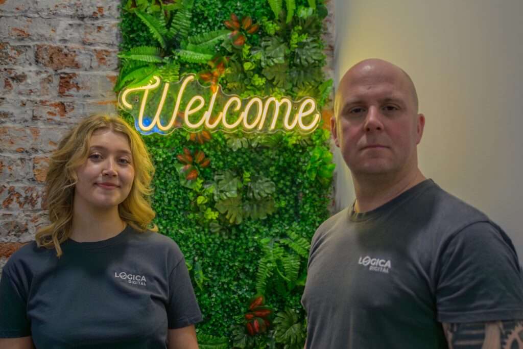 Team stood by the Welcome sign